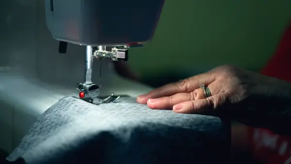 person in gray shirt sewing