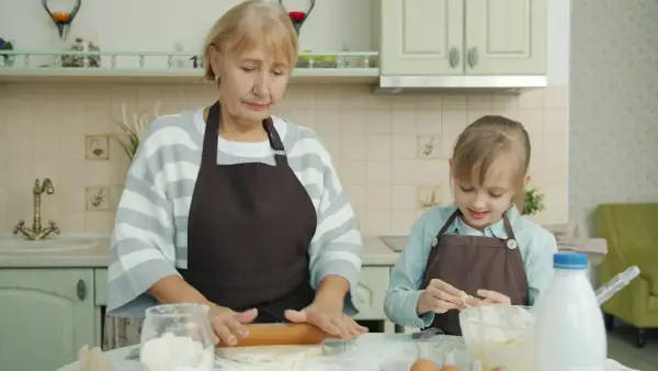 Grandmother and child baking together in kitchen