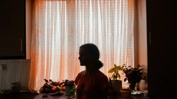 Silhouette of a woman in front of a sunlit window.