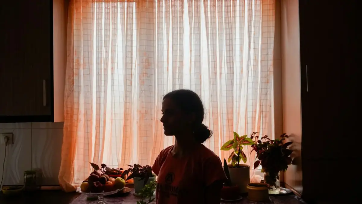 Silhouette of a woman in front of a sunlit window.