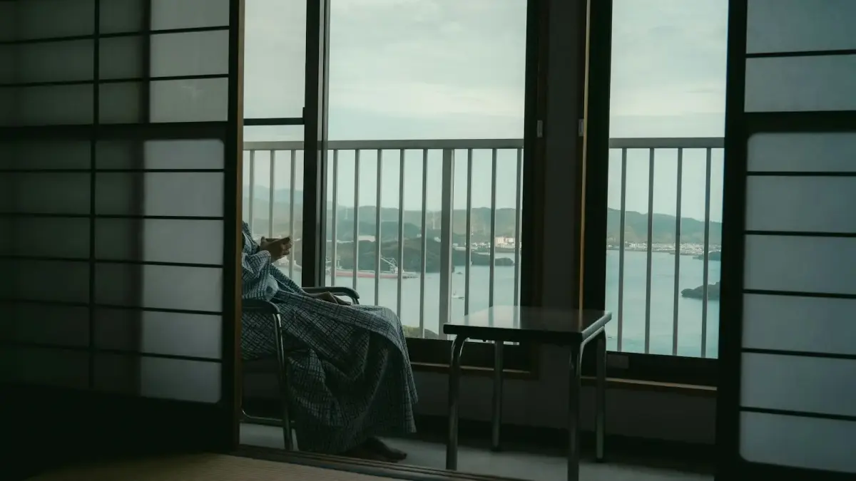 Person wrapped in blanket looking out window