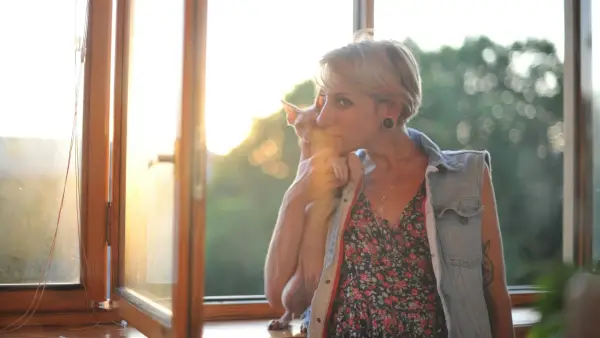 woman in gray blazer standing beside glass window during daytime